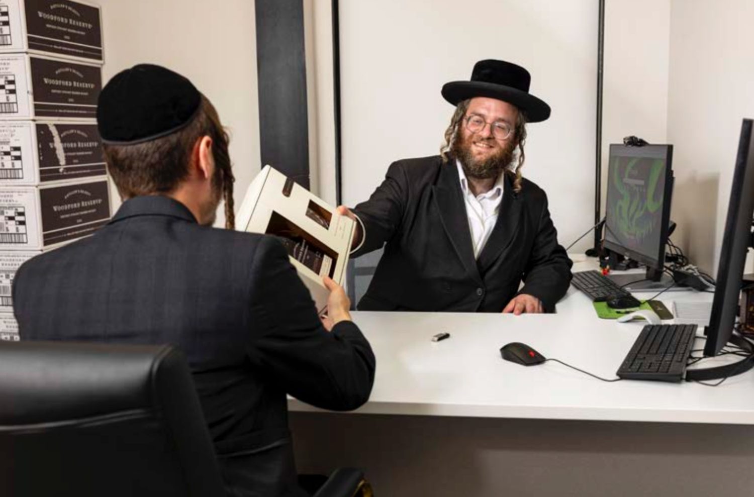 Jacob Rottenberg handing over project documents to a developer at the Ez Cloud office